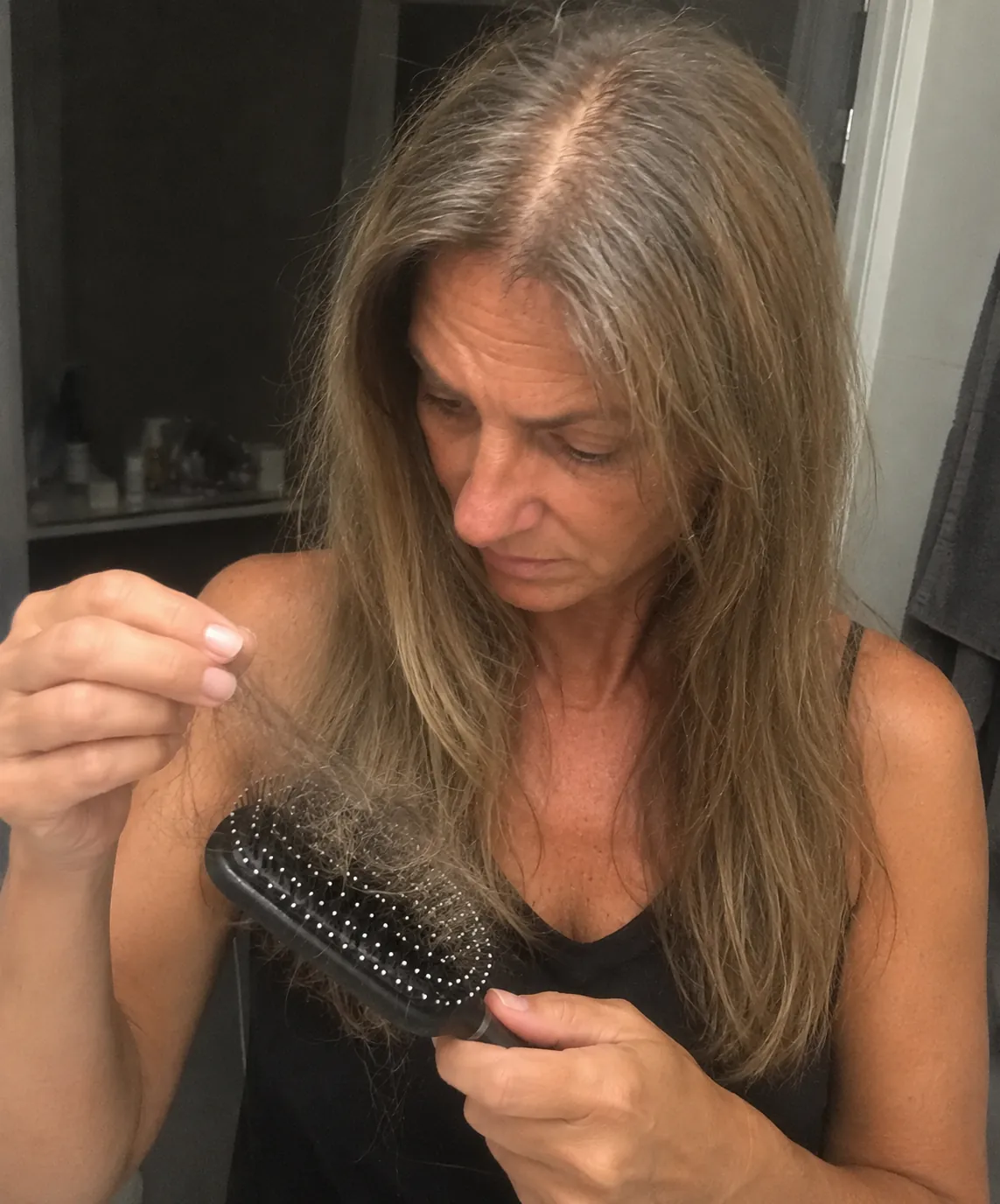 Donna che guarda i capelli rimasti nella spazzola